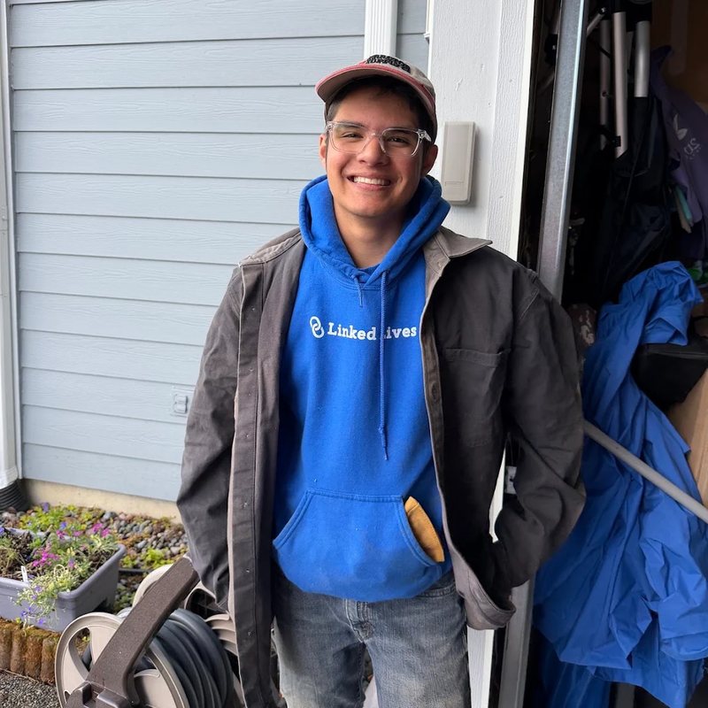 Smiling Linked Lives helper in a blue hoodie after a home visit