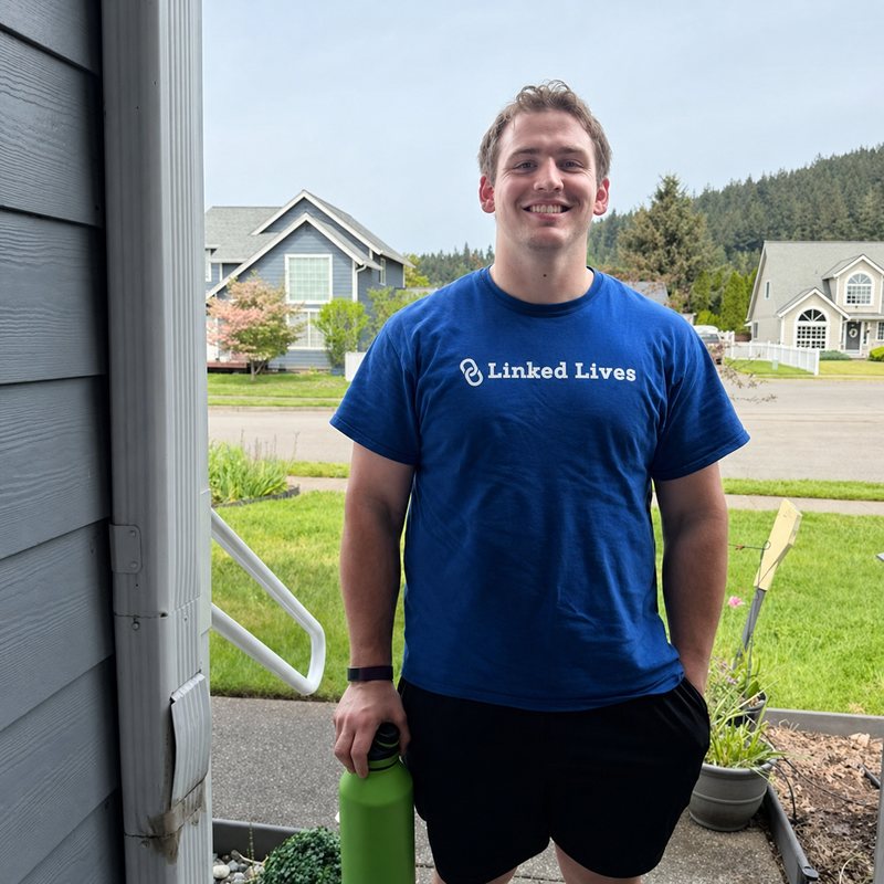Smiling Linked Lives helper standing by a porch