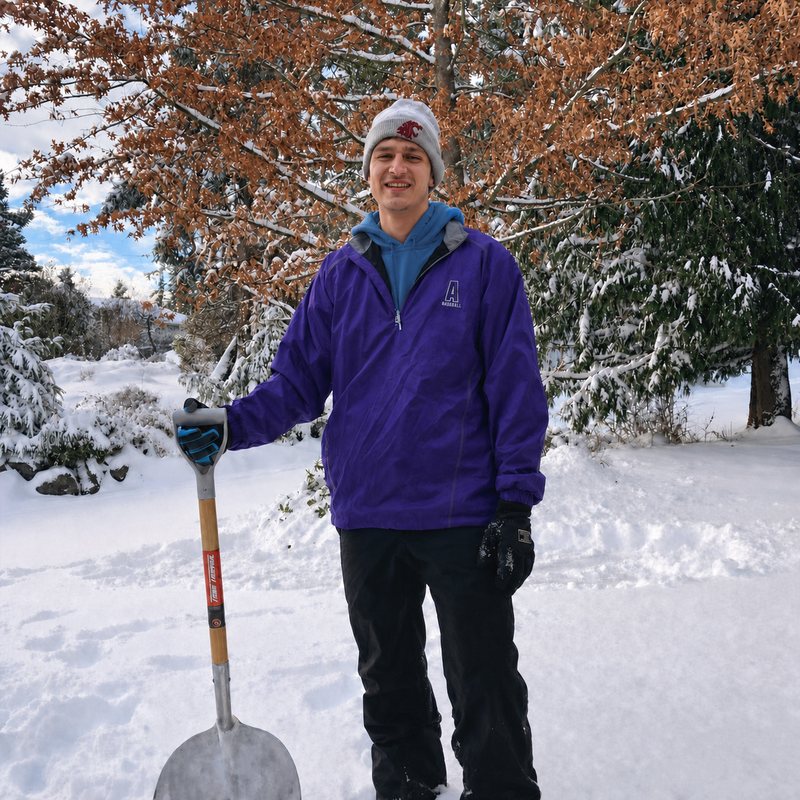 Linked Lives helper with a snow shovel after clearing snow